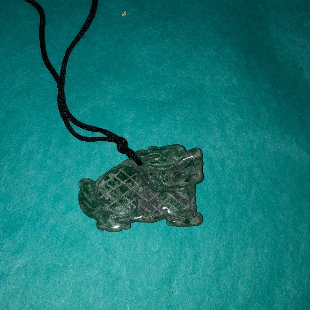 Carved jade charm on silk rope